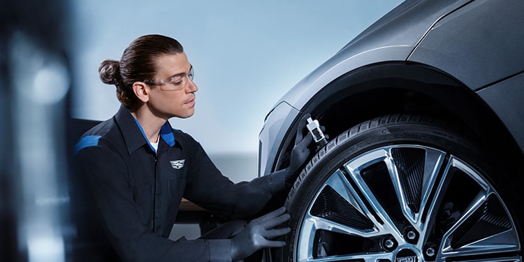 Cadillac Certified Service Technician Inspecting the Tire Tread on a Vehicle