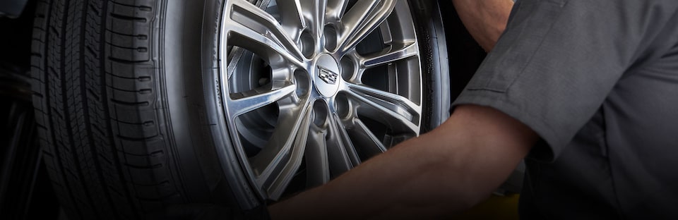 Cadillac Certified Service technician rotating a vehicle’s tires