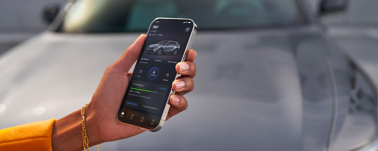 Close-up of a Woman Using the myCadillac App on Her Phone in Front of a LYRIQ