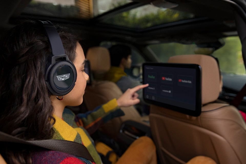 A Girl in the Back Seat of a Cadillac Utilizing the Second Row Touchscreen Display Screens