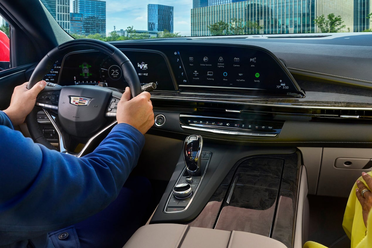 Back Seat View of the Infotainment System in a Cadillac Vehicle While a Man Drives in the City