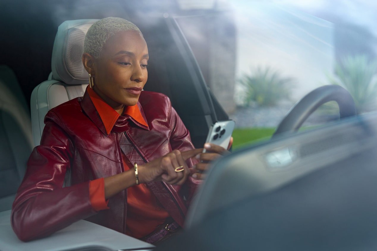 A Woman in the Driver Seat Using Her Smartphone to Use OnStar Remote Commands