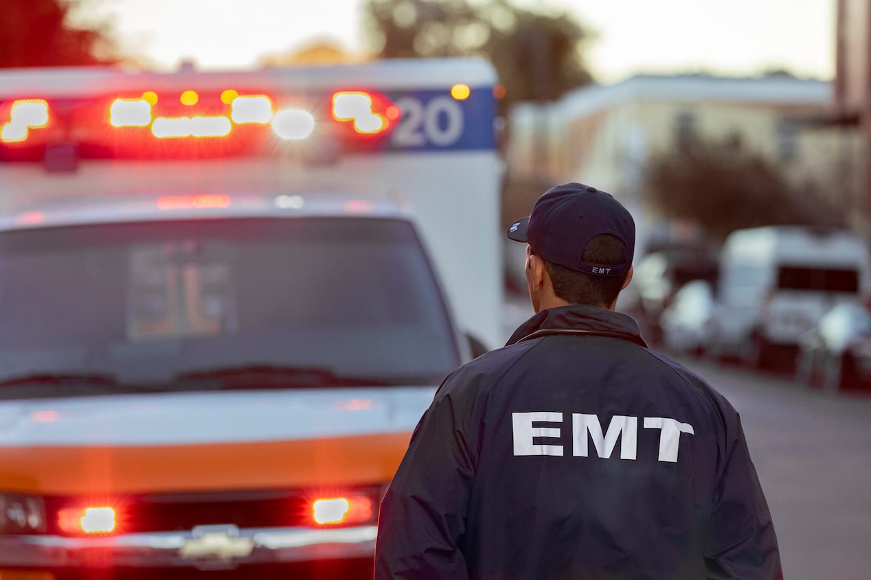 Close-up of an EMT Worker Facing an Ambulance in the Street