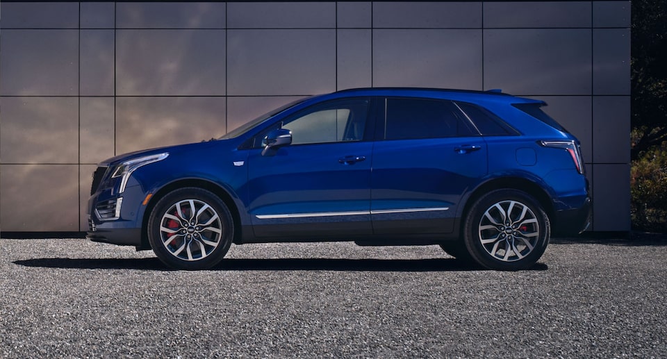 Cadillac XT5 SUV Parked on Gravel in Front of a Building