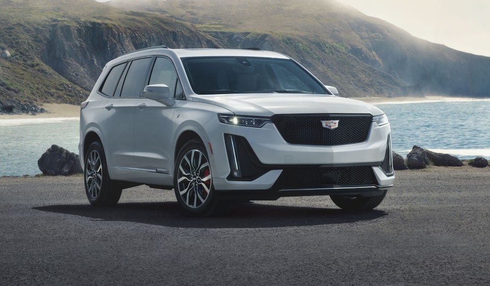 Cadillac XT6 SUV Parked in Front of a Lake and Mountains