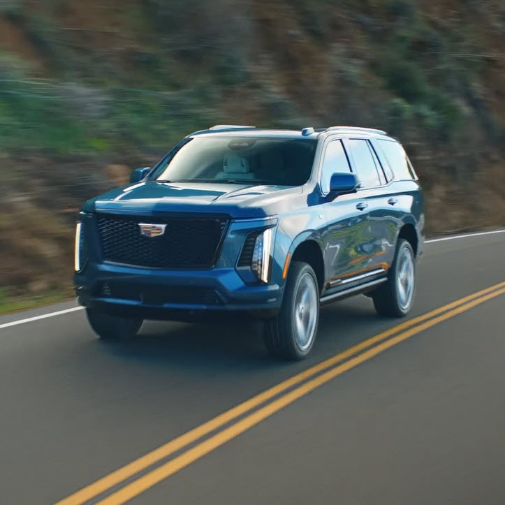 A Blue 2025 Cadillac Escalade Driving Through the Mountains