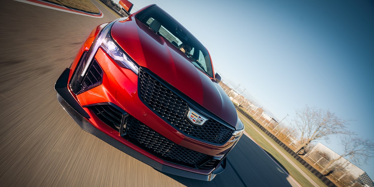 Close-up of the Front of a Red Cadillac CT4-V Driving Down a Track