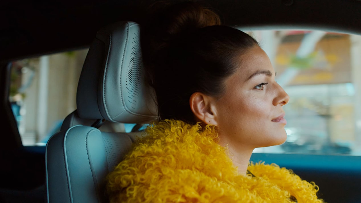 A Woman Happily Drives Her Cadillac LYRIQ in the City