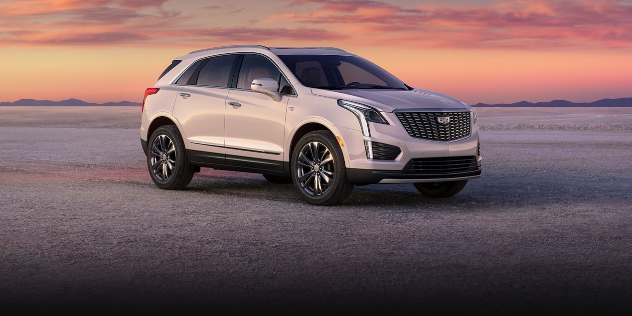 Three-quarter View of a White 2025 Cadillac XT5 Parked in the Desert During Twilight