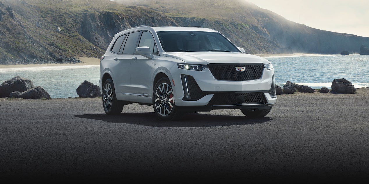 2025 Cadillac XT6 SUV Parked in Front of a Lake and Mountains