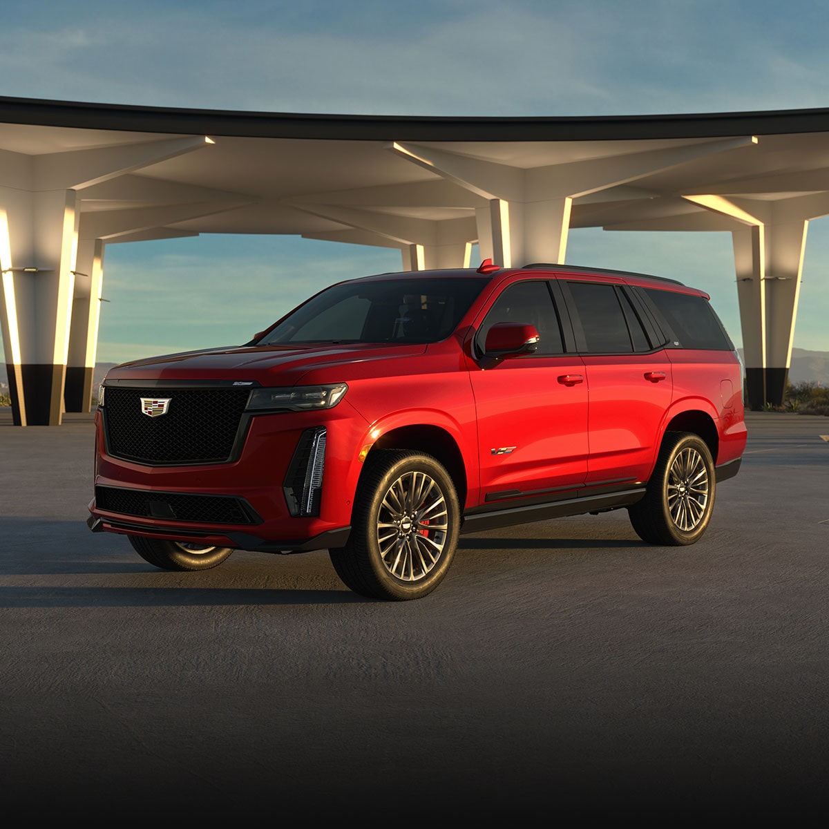 Three-quarter View of a Red 2025 Cadillac Escalade-V Parked Under an Overpass