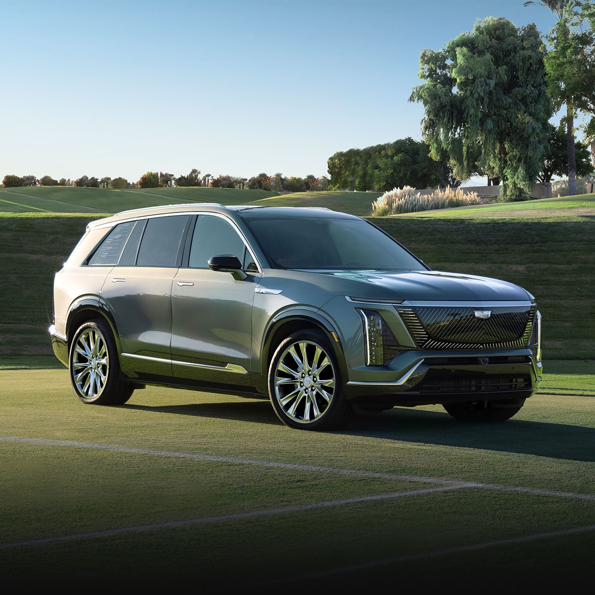 Three-quarter View of a 2026 Cadillac VISTIQ Parked on a Grassy Tennis Court